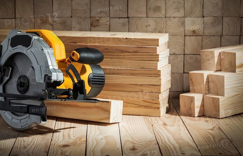Electric power tool corded circular hand saw on wooden background