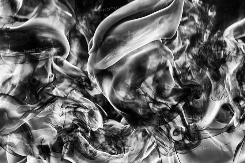 Abstract plume of natural black smoke and white huge flame of strong fire, motion blur from fire, high temperature flames. Dramatic moody black and white image. Dangerous firestorm abstract background