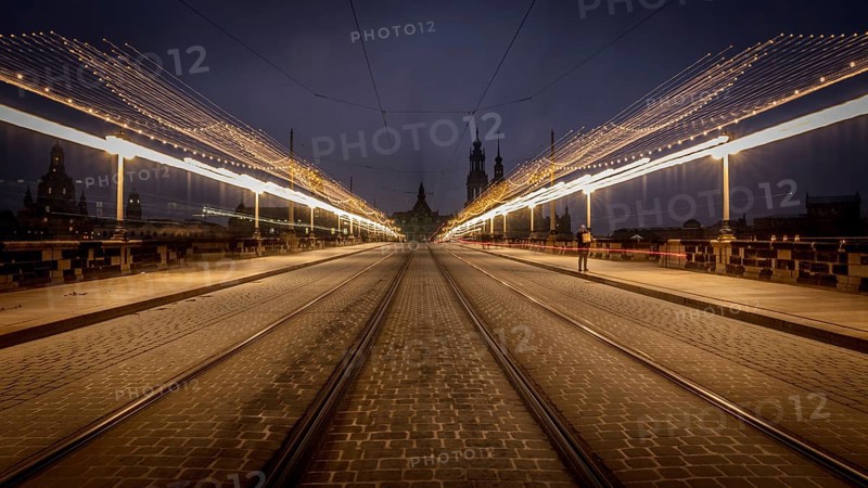 Long exposure at night of a street with fairy lights and street lamps leading to a central point, Christmas market Augustusbrücke Dresden