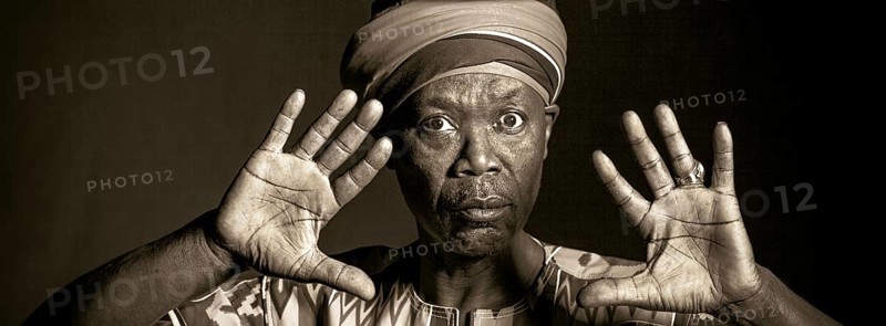 African man in traditional clothes toothy smile, on grey background