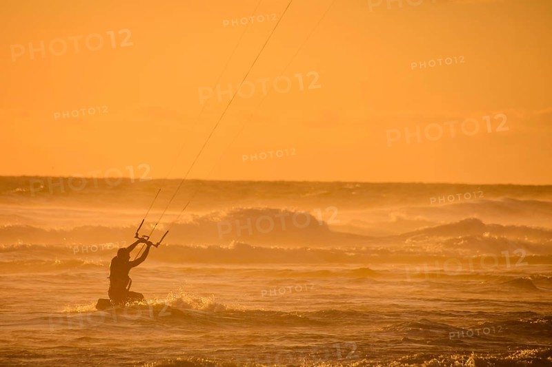 Single surfer at sunset on a calm ocean