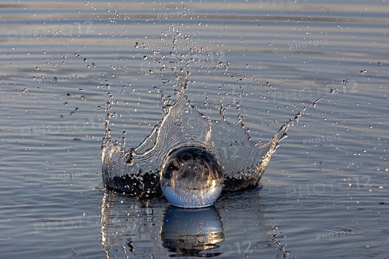 A glass sphere creates water droplets with a dynamic water crown, Mindelheim, Allgäu, Bavaria, Germany, Europe