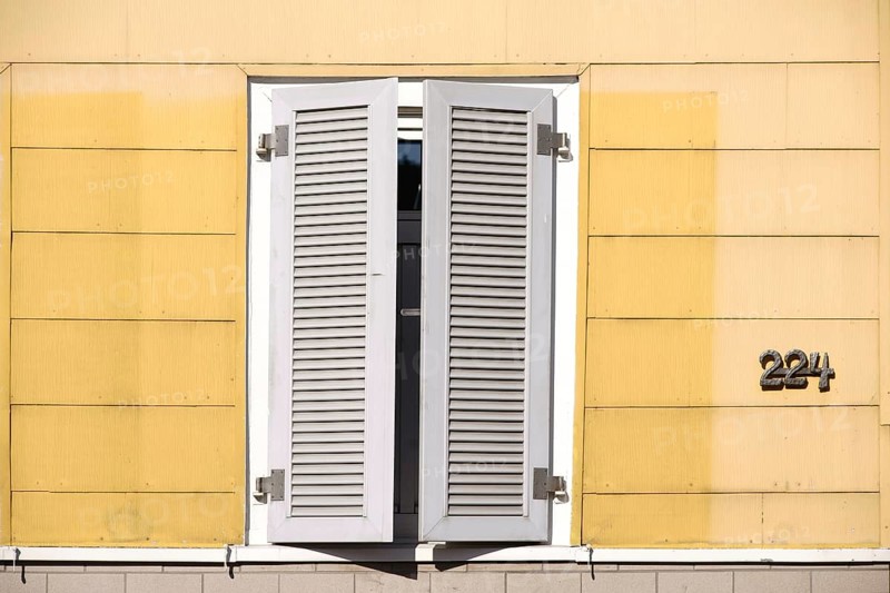 A closed new wooden shutter on a residential building