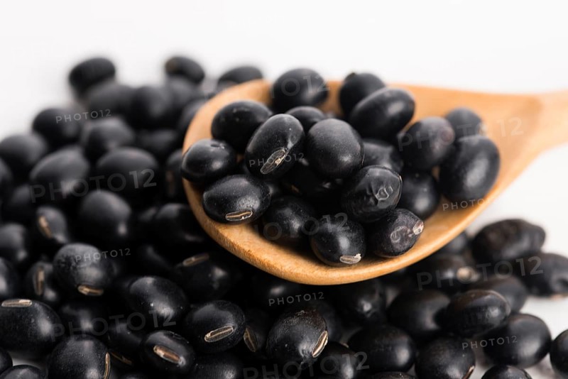 A lot of black soybeans on wooden background