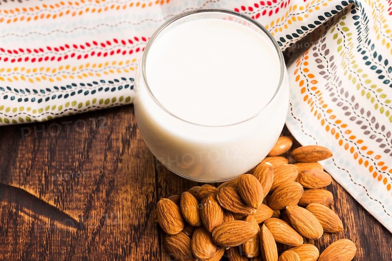 Almond milk with almond on a wooden table