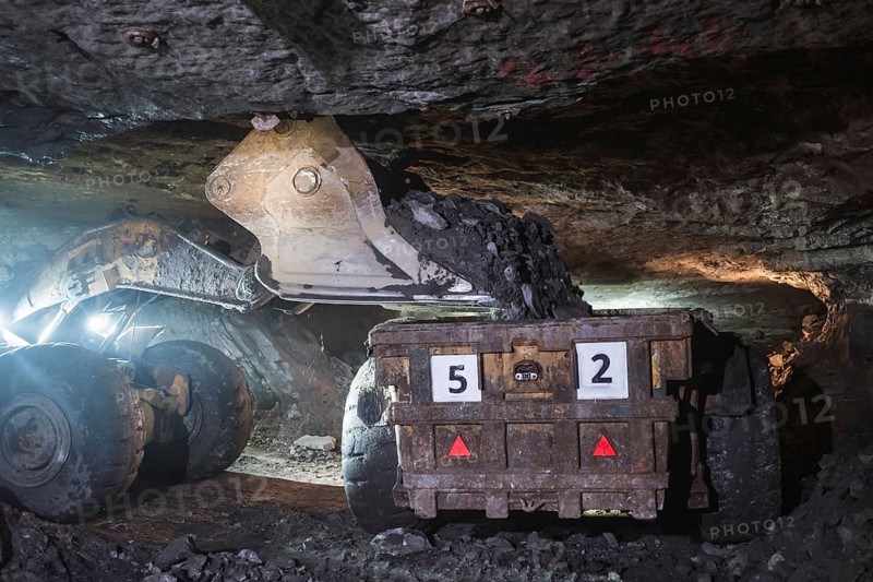 The loader pours copper ore on a truck in the mine