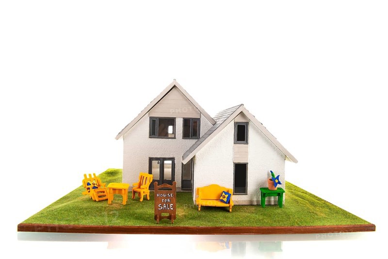Miniature house for sale isolated over white background