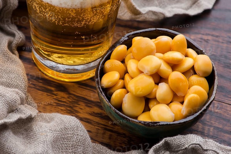 Tasty lupins and glass of beer. Beverage, legume