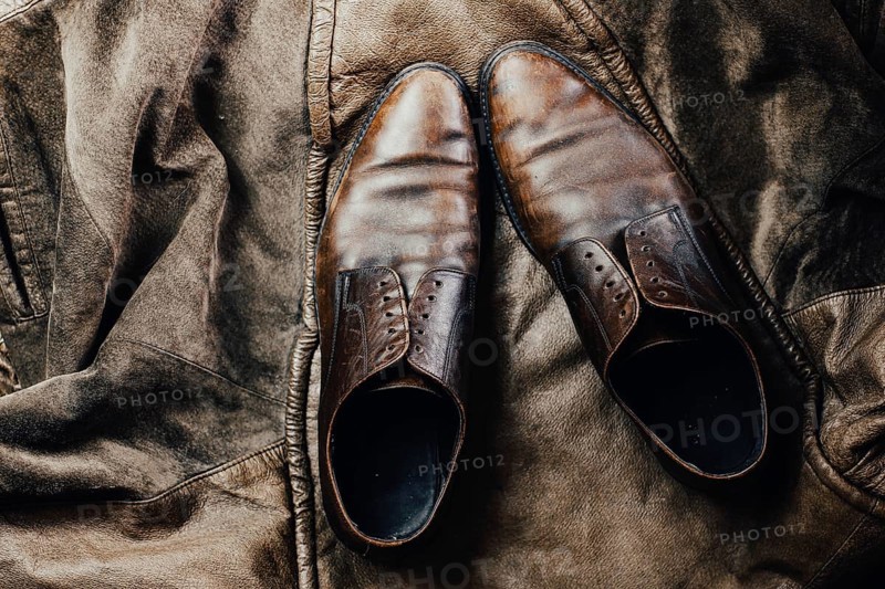 Brown leather shoes paired with a leather jacket, enhancing a vintage and rustic feel