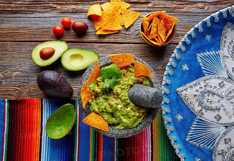 Guacamole with nachos avocado in Mexican molcajete and Sombrero hat