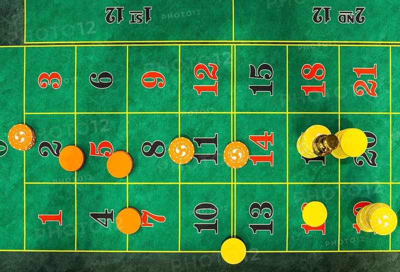 Roulette table chips in a casino. Closed up of casino roulette gambling table game. Yellow and orange chips