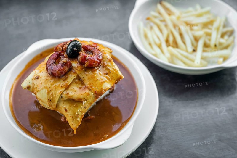 Famous francesinha traditional meat cheese and spicy sauce grilled sandwich of porto portugal