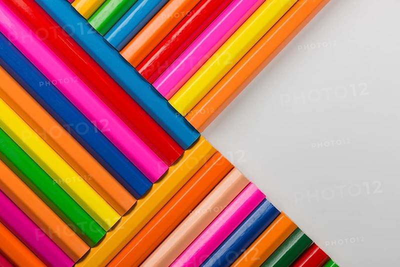 Abstract composition of a set wooden colour pencils against a white background