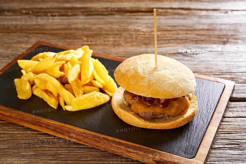 Burguer and french fries potato chips on wood table