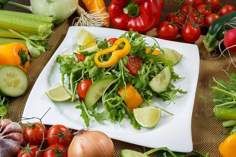 Healthy eating background. Different vegetables and salad with leaf vegetables and cherry tomatoes on white plate