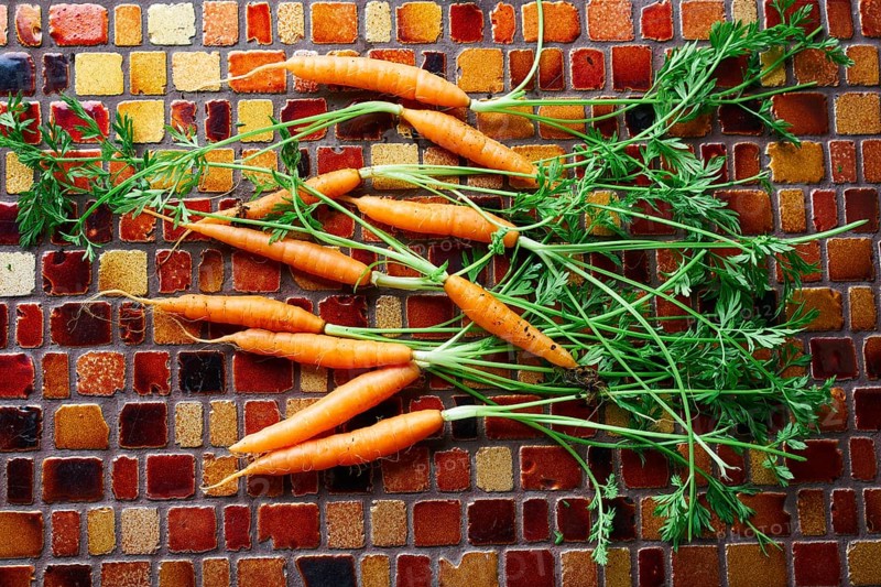 Mini Carrot vegetables on a tiles table background