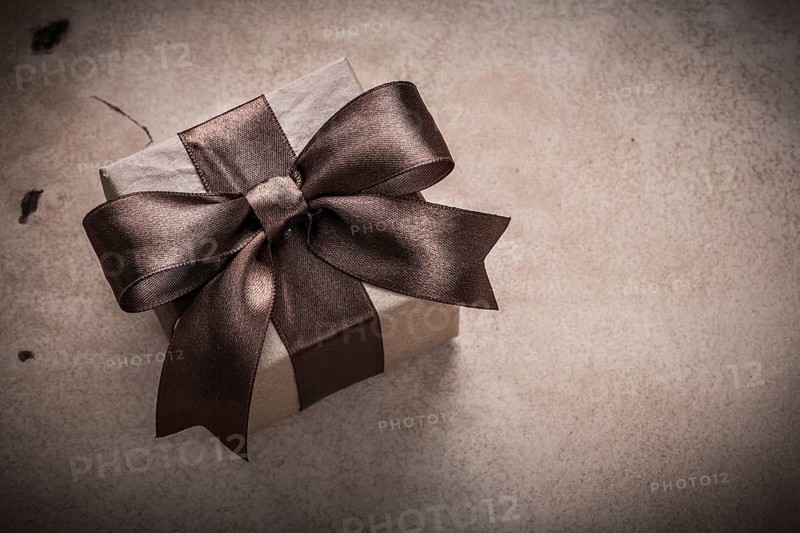 Present box with tied bow paper on vintage background