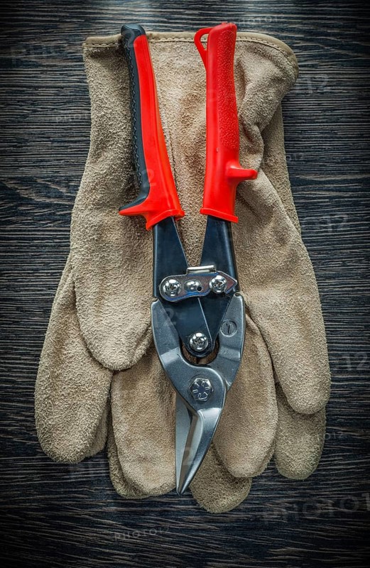 Protective gloves steel cutter on wooden board