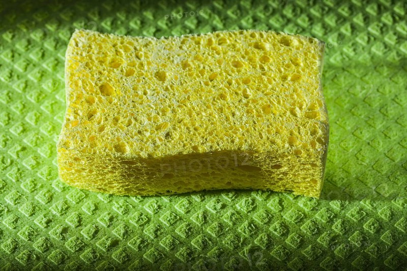 New yellow sponge on green washcloth