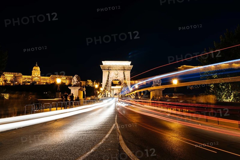 Chain Bridge and Buda castle illuminated in Budapest at night. Long exposure shot with light trails