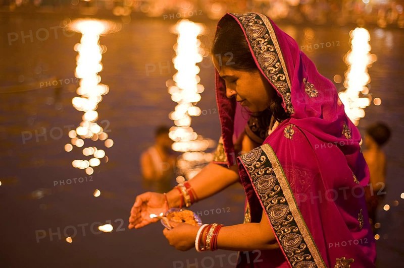 Woman offering oil lamp to godavari river, Nasik, maharashtra, india, asia