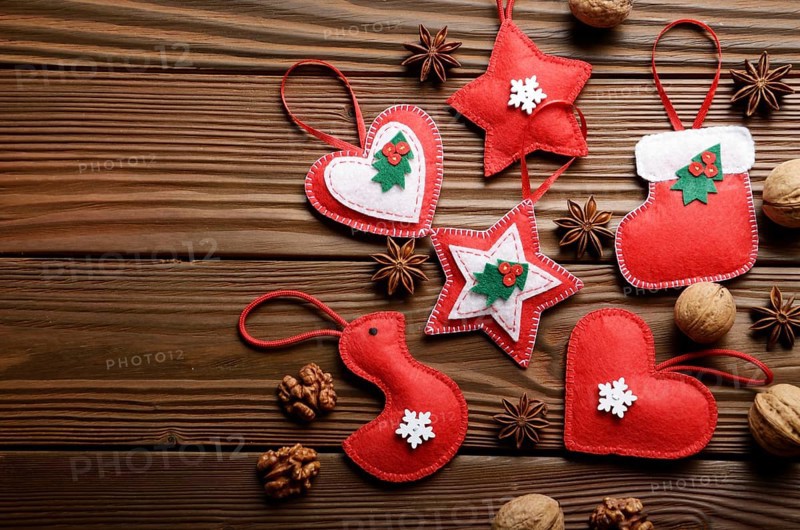 Handmade rustic Christmas tree decorations with walnuts and cones on wooden table