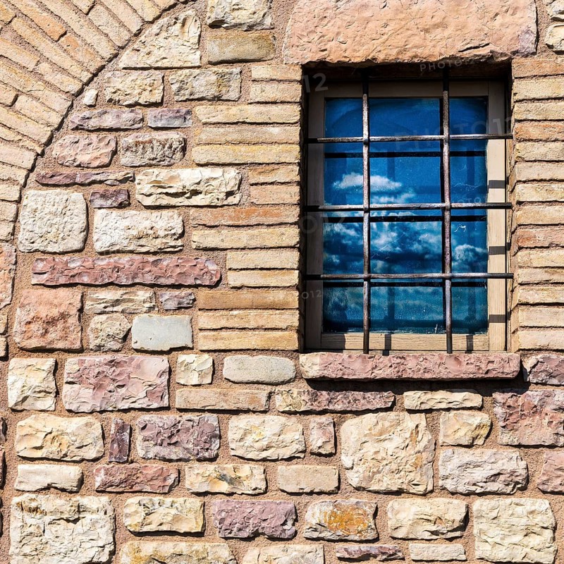 Assisi Italy : Window on medieval stone wall