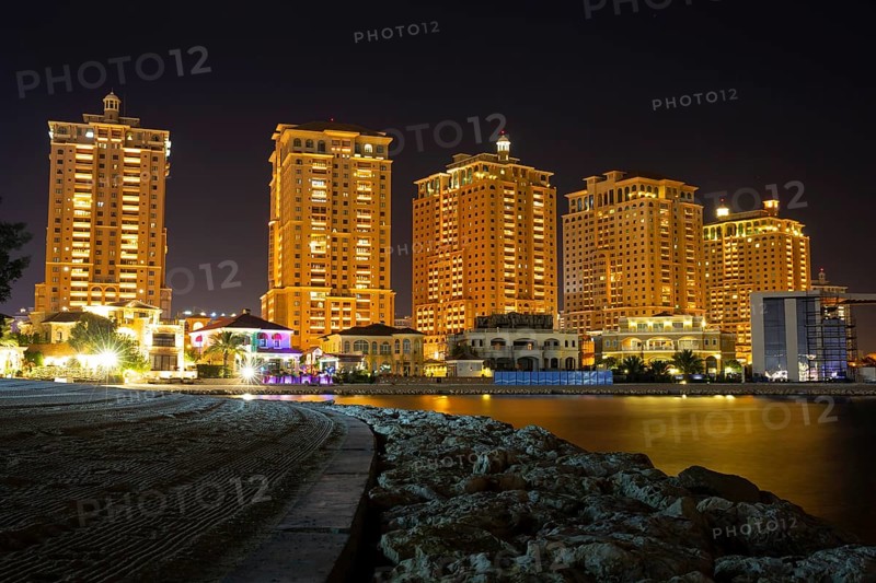 The skyline panorama of The Pearl-Qatar area buildings in Doha, Qatar at night. The Pearl-Qatar is an artificial island spanning nearly four square kilometers. Long exposure