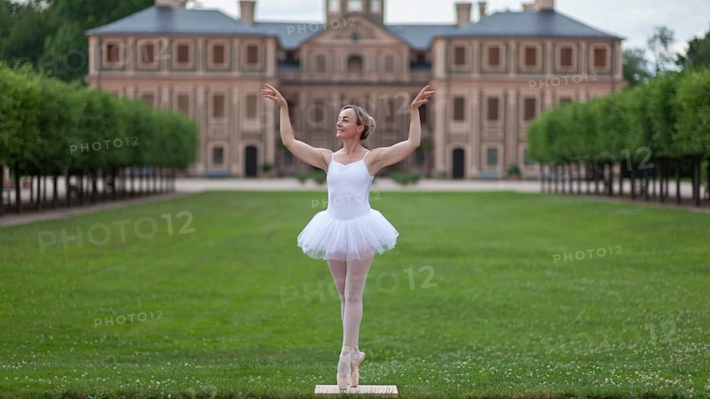 Ballerina in a white tutu dancing in the park of a palace, surrounded by green trees and symmetrical layout, Favorite Palace, Rastatt, Baden-Württemberg, Germany, Europe