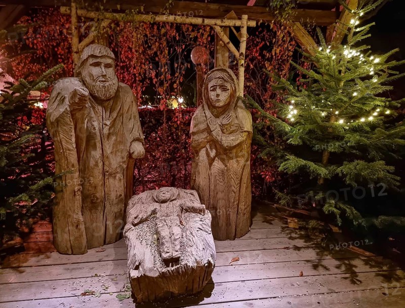 Traditional Christmas nativity scene with figures made out of wood, the birth of Jesus Christ in the manger surrounded by Joseph and Mary.