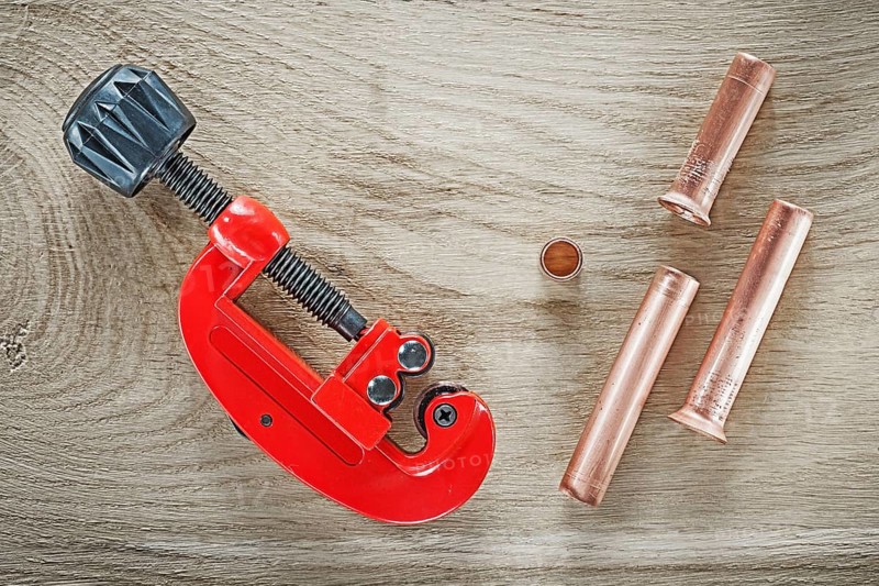 Flared pipes tube cutter on wooden board