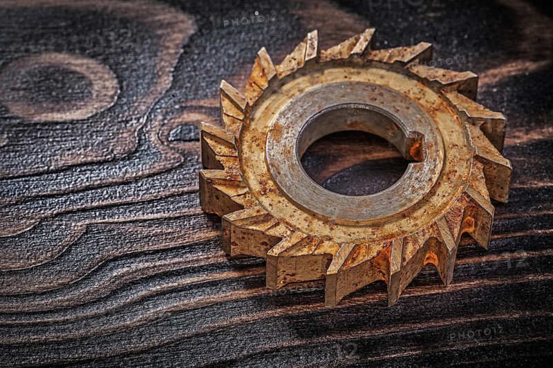 Rusted rotary cutter on vintage wood background construction concept