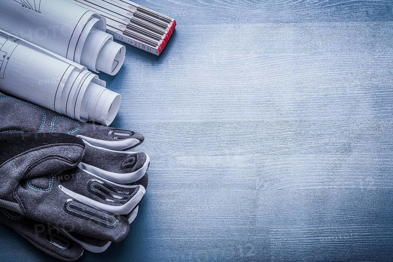 Copyspace image working gloves rolled blueprints and wood meter