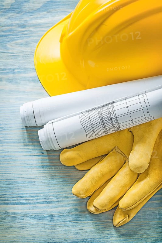 Hard hat construction plans protective gloves on wooden board building concept