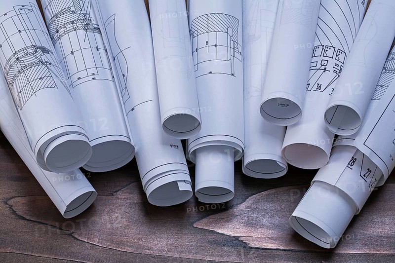 Rolls of construction plans on pine wooden vintage board maintenance concept
