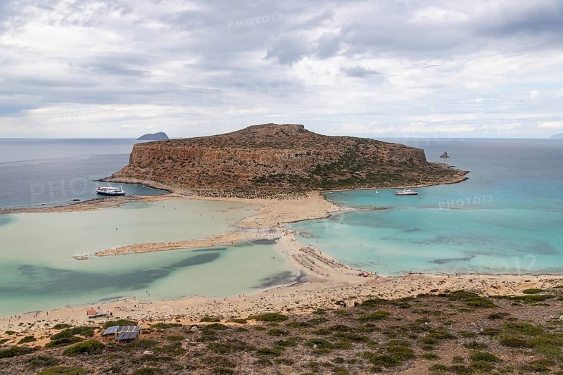 A picture of the blue water of Balos Beach and the nearby landscape of the Gramvousa Peninsula
