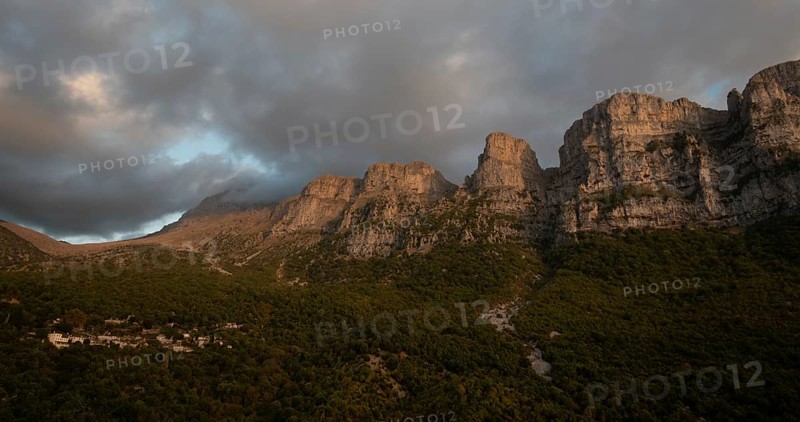Drone scenery mikro Papingo village, Zagorochoria area, Epirus, Ioannina Greece. Astraka tower rocky cliffs above the village at sunset