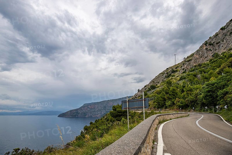 Coastal landscape shot. View from a road leading along the sea and through a breathtaking green Mediterranean landscape. Coast near Salerno, Italy, Europe