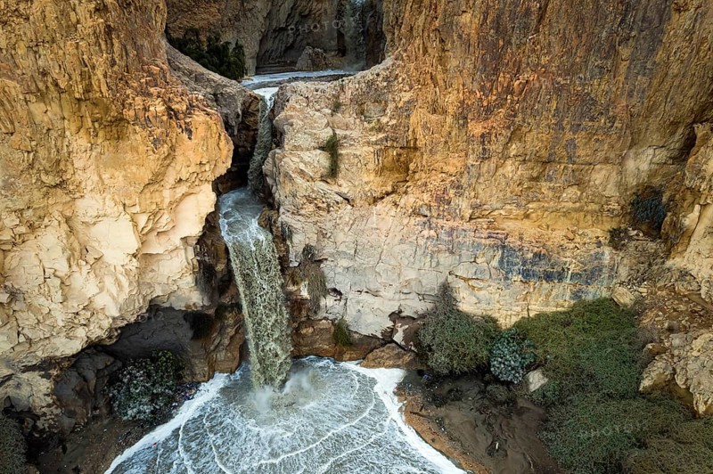 Powerful waterfall in the Judean Desert around the Dead Sea after heavy winter rains. Israel. Abstract image of a real event. Original unexpected angle. Shooting from a drone