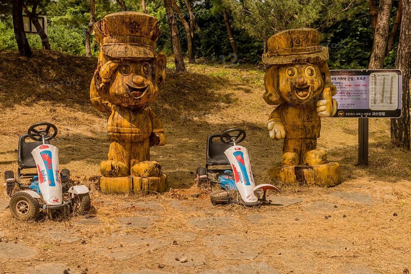 Geosan, South Korea, August 26, 2020: Carved wood statues of Korean police officers in mountain recreational forest on sunny day, Asia