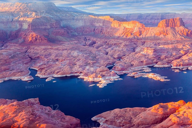 U.S. The coast of Lake Powell is cut by narrow canyons. Grandiose huge lake of artificial origin among the picturesque red sandstone cliffs. Landscape under the wing of an airplane