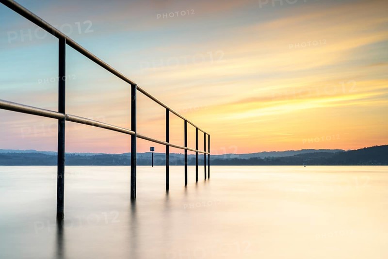 Railing in the lake in the warm light of the sunset, quiet atmosphere, lido, Litzelstetten, Lake Constance, Baden-Württemberg, Germany, Europe