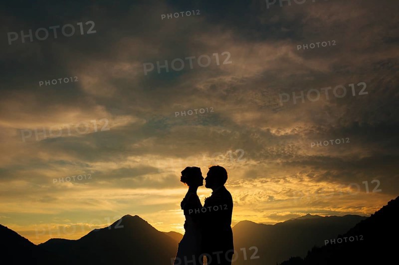 Silhouette of a newlywed couple on the background of the setting sun on the sea in Montenegro