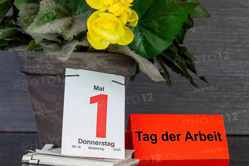 May Day: The page of a tear-off calendar shows the date 1 May, next to it a piece of paper with the added text DAY OF WORK