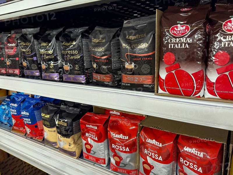 Display shelf with various types of packs of unground coffee beans, Germany, Europe