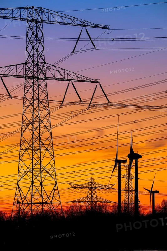 High-voltage electricity pylons, transmission towers and wind turbines at sunset near the Borssele Nuclear Power Station, Zeeland, Netherlands