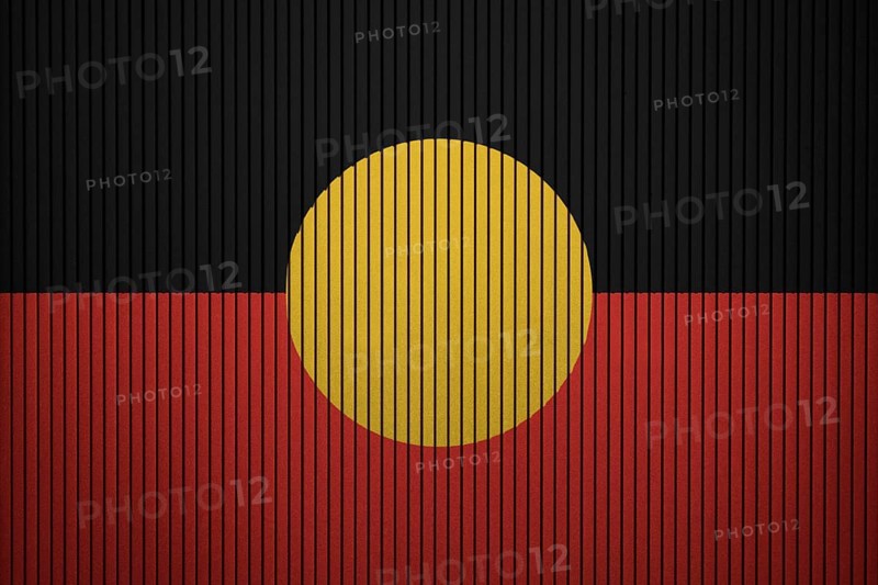 Australian Aboriginal flag painted on the cracked grunge concrete wall
