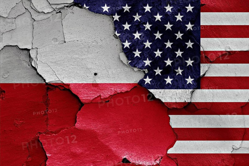 Flags of Poland and USA painted on cracked wall