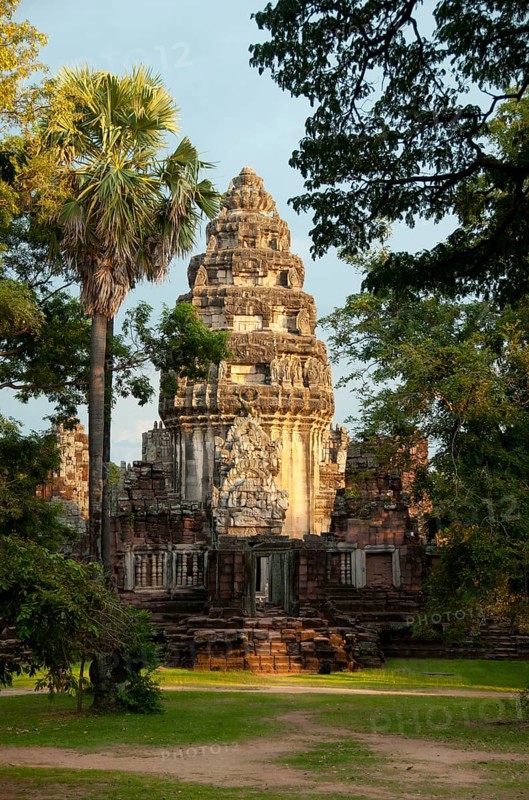 The complex at Phimai dates originally from the reign of Surayavarman II (r. 1113 - 1150), during the first part of the 12th century CE. The temple was constructed with white, finely-grained sandstone, in the same style as Angkor Wat. Like Angkor, too, Phimai was first dedicated to the cult of Vishnu. The central sanctuary tower and much of the immediate surrounding which survive today date from this early period.<br/><br/> About one hundred years later, when Jayavarman VII (r. 1181 - 1218), 'the builder', extended and developed Phimai, the temple became a Mahayana Buddhist centre, dedicated to the Vimaya Buddha. The name 'Phimai' is derived from this.<br/><br/> The basic structure of Jayavarman's city is readily identifiable today. The complex sits in a large rectangle which once contained a small town, and was surrounded on all four sides by water – the Mun River to the north, a natural canal to the west, and two man-made canals to the south and east. The south wall of the city was p...