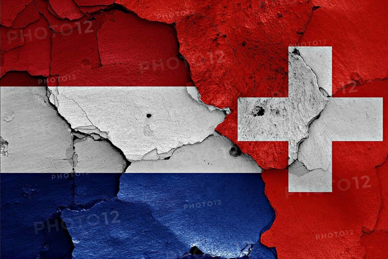 Flags of Netherlands and Switzerland painted on cracked wall